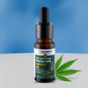 Bottle of Cannama full spectrum hemp leaf extract oil with a dropper on a blue background
