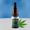 Bottle of Cannarma full spectrum hemp leaf extract oil with a dropper on a blue and gray background.
