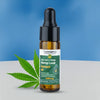 Cannama full spectrum hemp leaf extract oil bottle with a dropper and cannabis leaf on a blue and gray background